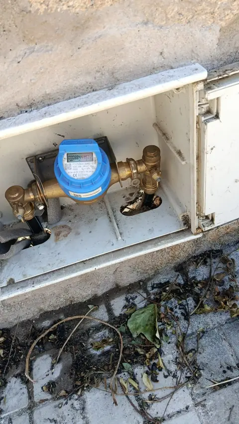 Montaje de contador de agua con llaves de paso en armario de acometida.