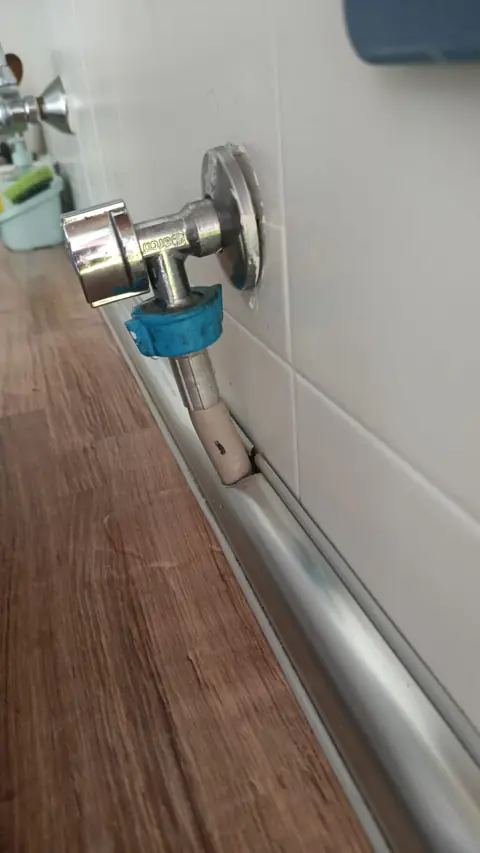 Toma de agua para lavadora con llave de escuadra y tubería multicapa.