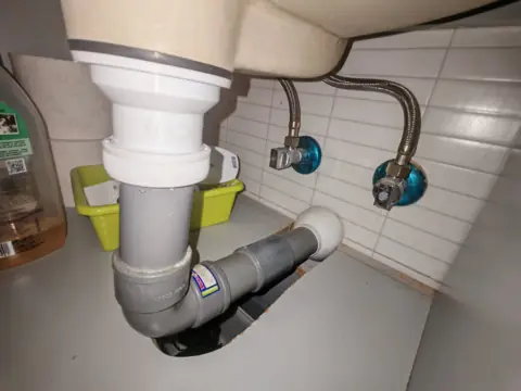Instalación de válvula y sifón de lavabo en PVC con llaves de escuadra y latiguillos.