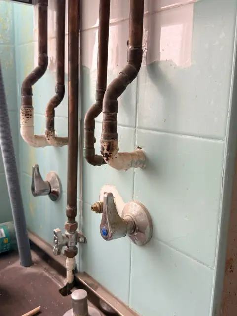 Instalación antigua de cobre y llaves de paso antes de su renovación.